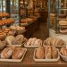 Vitrine de boulangerie élégante présentant des pains artisanaux, des croissants et des pâtisseries dans un agencement chaleureux et soigné.